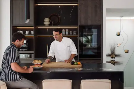Chef interactuando con un huésped en la cocina del 7Pines Resort Ibiza.