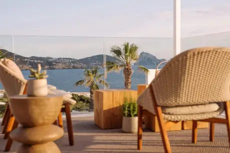 Terraza con vista al océano y palmeras en 7Pines Resort Ibiza.