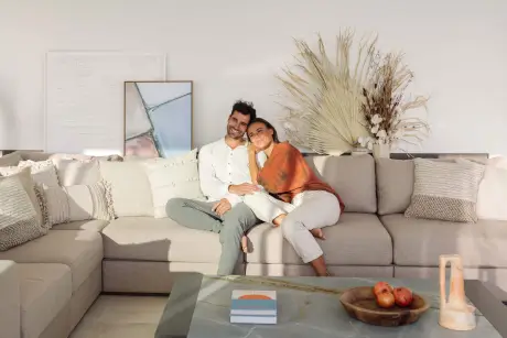 Una pareja disfrutando de un momento acogedor en un sofá en una sala de estar elegante en 7Pines Resort Ibiza.