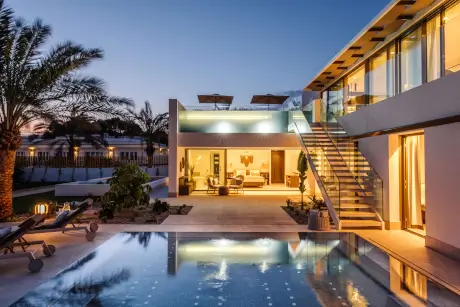 Villa de lujo con piscina y palmeras en 7Pines Resort Ibiza.